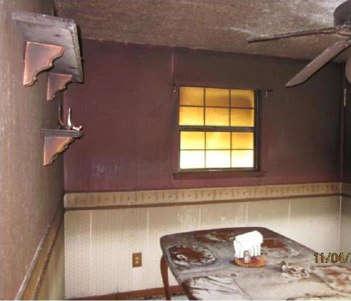 Dining room with visible smoke damage and soot on surfaces