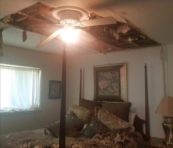 Water damage causing a ceiling to cave in over a bed