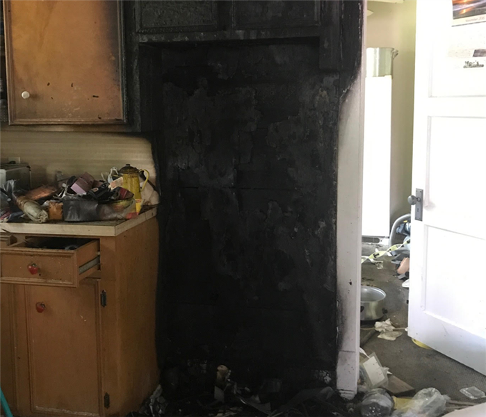 Charred wall and fire damage in residential kitchen