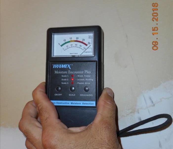 Moisture meter detecting water in a wall 